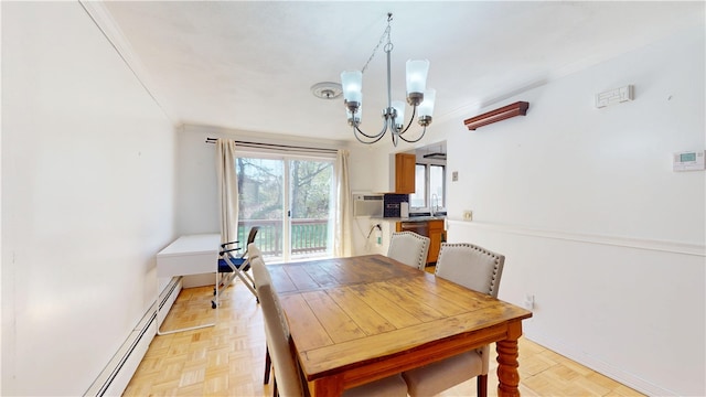 dining space featuring crown molding, an inviting chandelier, and baseboard heating