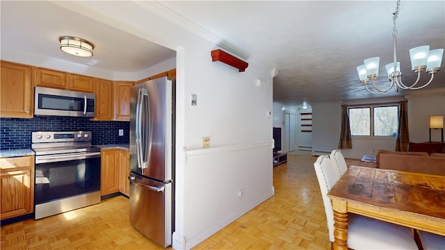 kitchen with decorative backsplash, baseboards, open floor plan, a chandelier, and appliances with stainless steel finishes