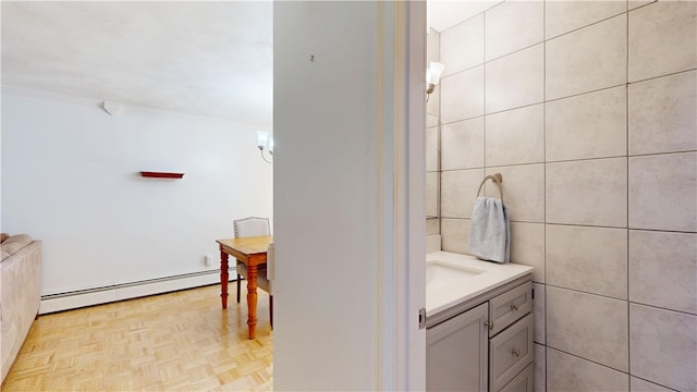 bathroom with vanity, a baseboard heating unit, and tile walls
