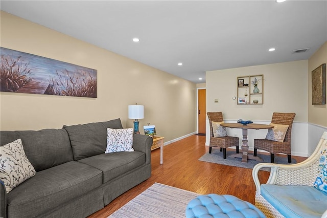 living area featuring visible vents, recessed lighting, baseboards, and wood finished floors