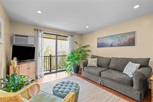 living area featuring an AC wall unit, recessed lighting, and wood finished floors