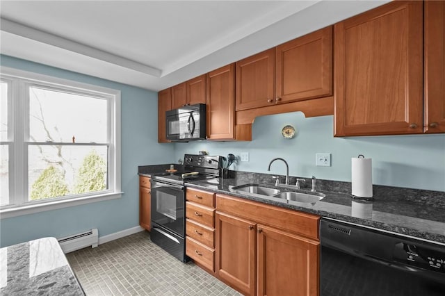 kitchen with baseboard heating, dark stone counters, brown cabinets, a sink, and black appliances