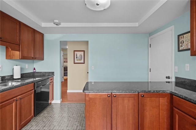 kitchen with brown cabinetry, dark stone countertops, a peninsula, and black dishwasher
