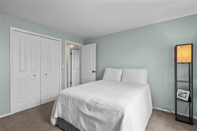 bedroom with baseboards, carpet, and a closet