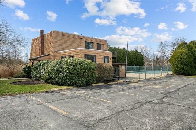view of side of home with fence and uncovered parking