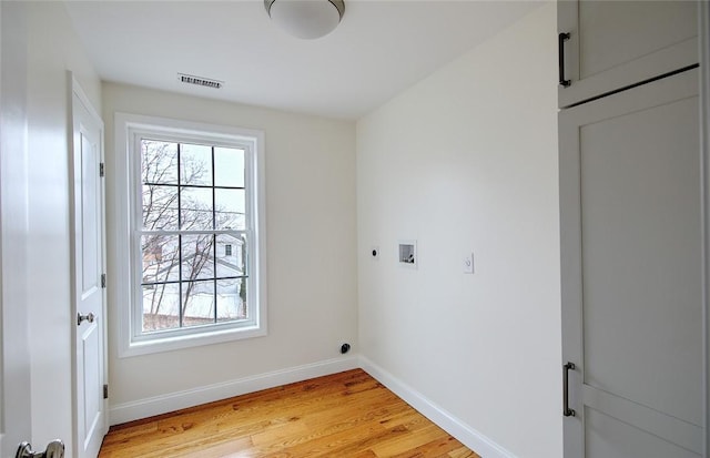 clothes washing area with laundry area, light wood finished floors, baseboards, electric dryer hookup, and visible vents