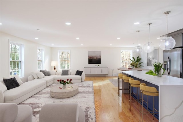 living area featuring plenty of natural light, recessed lighting, and light wood finished floors