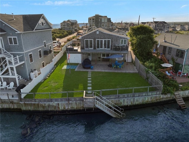 rear view of property with a fenced backyard, stairs, a patio, and a yard