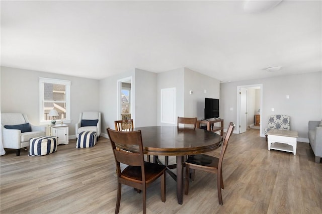 dining room with light wood finished floors and baseboards
