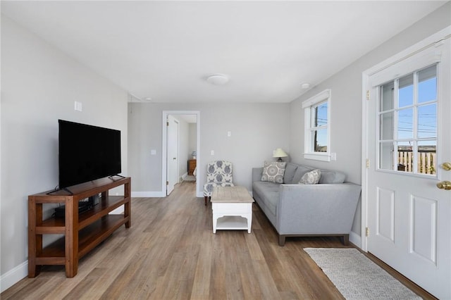 living area featuring baseboards and light wood-style floors