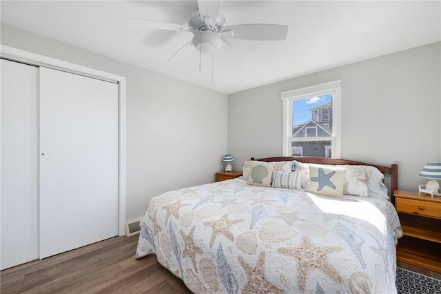 bedroom with ceiling fan, a closet, visible vents, and wood finished floors