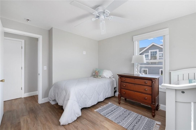 bedroom featuring ceiling fan, baseboards, and wood finished floors