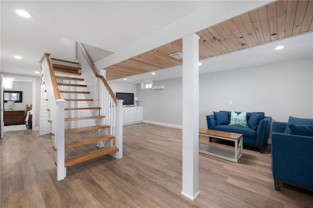 finished below grade area with recessed lighting, stairs, baseboards, and wood finished floors