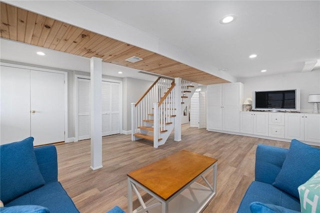 living room featuring stairway, light wood finished floors, baseboards, and recessed lighting