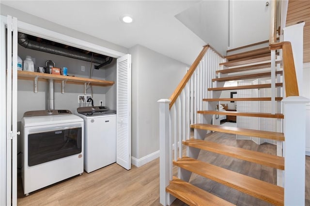 washroom featuring laundry area, recessed lighting, separate washer and dryer, light wood-style flooring, and baseboards