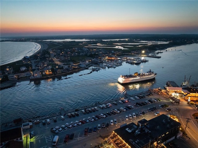aerial view at dusk featuring a water view