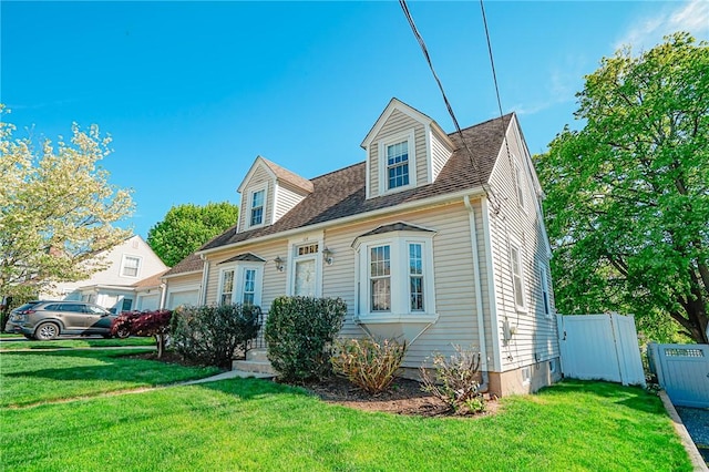 view of front of property featuring a garage, fence, and a front lawn