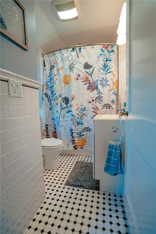 bathroom with tile patterned flooring, a shower with shower curtain, and toilet