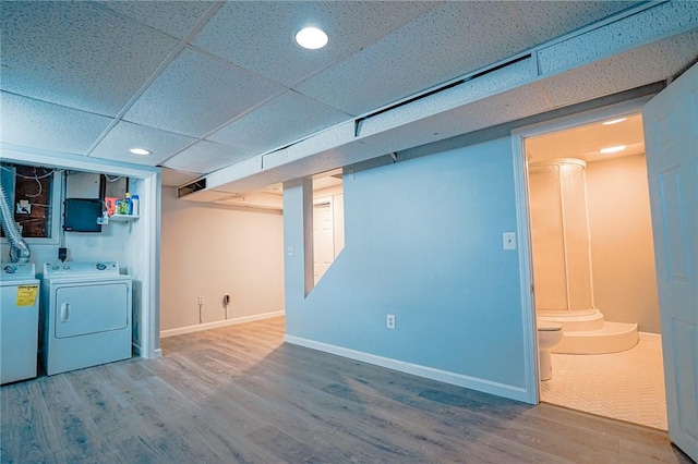 finished below grade area featuring independent washer and dryer, a paneled ceiling, recessed lighting, baseboards, and wood finished floors