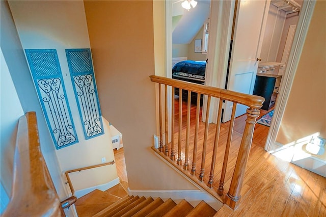 staircase with baseboards and wood finished floors