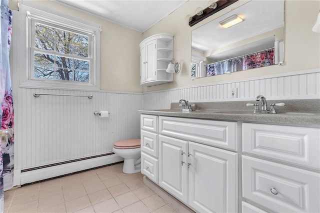 105 Quaker Dr, West Warwick, RI 02893 - full bathroom with a sink, toilet, a baseboard radiator, tile patterned flooring, and wainscoting