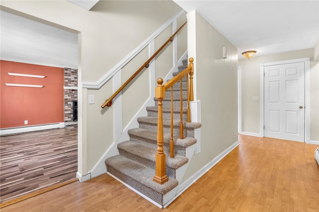 105 Quaker Dr, West Warwick, RI 02893 - stairs featuring baseboards, baseboard heating, and wood finished floors