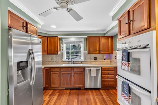 105 Quaker Dr, West Warwick, RI 02893 - kitchen with wood finished floors, a sink, crown molding, light countertops, and appliances with stainless steel finishes