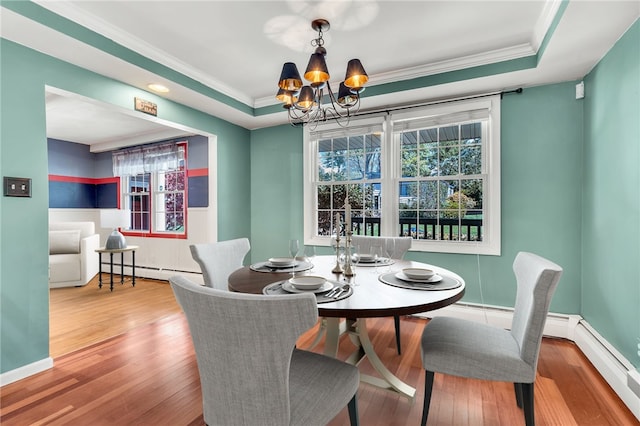 105 Quaker Dr, West Warwick, RI 02893 - dining area with baseboard heating, an inviting chandelier, wood-type flooring, crown molding, and a raised ceiling