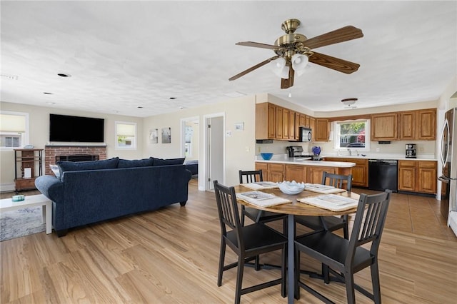 106 N River Dr, Narragansett, RI 02882 - dining room featuring light wood finished floors, ceiling fan, and a brick fireplace