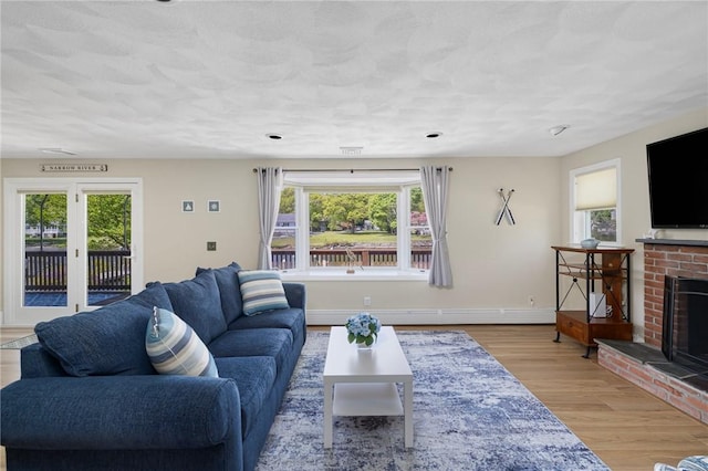 106 N River Dr, Narragansett, RI 02882 - living room featuring a brick fireplace, wood finished floors, and baseboards