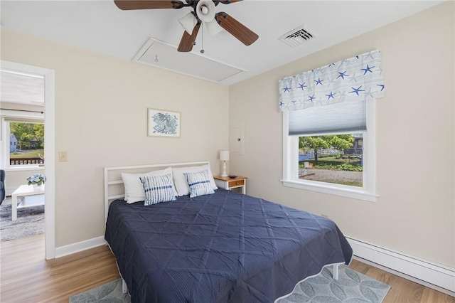 106 N River Dr, Narragansett, RI 02882 - bedroom featuring a baseboard heating unit, wood finished floors, attic access, ceiling fan, and baseboards