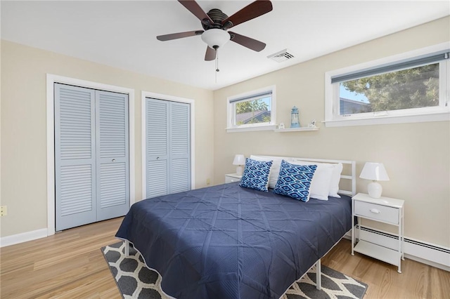 106 N River Dr, Narragansett, RI 02882 - bedroom featuring two closets, wood finished floors, baseboards, and a baseboard heating unit