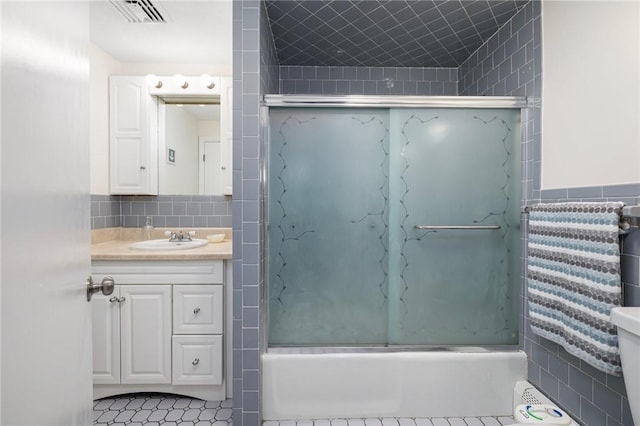 106 N River Dr, Narragansett, RI 02882 - full bath with tile walls, vanity, toilet, and shower / bath combination with glass door