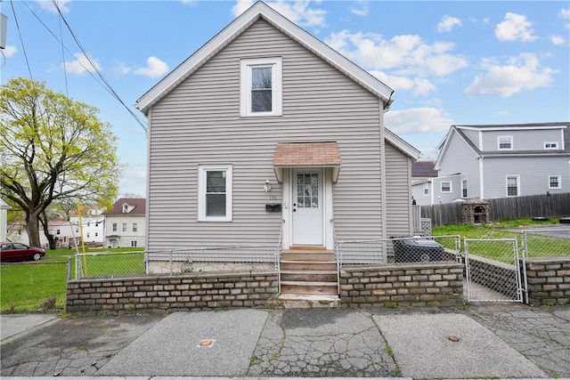 view of front of property featuring a gate, fence, and a front yard