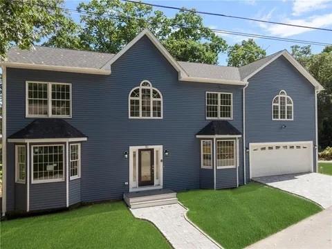 70 Shady Ln, Burrillville, RI 02859 - colonial-style house featuring an attached garage, concrete driveway, and a front lawn
