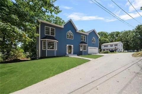 70 Shady Ln, Burrillville, RI 02859 - view of front of house featuring an attached garage, driveway, and a front lawn