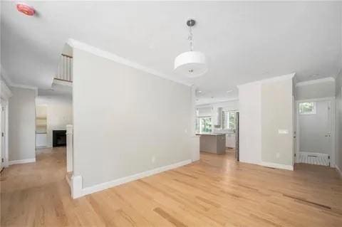 70 Shady Ln, Burrillville, RI 02859 - unfurnished living room featuring crown molding, light wood-type flooring, and baseboards
