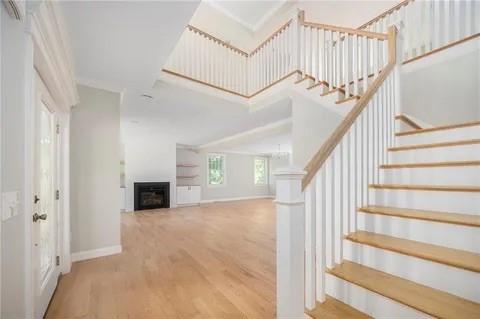 70 Shady Ln, Burrillville, RI 02859 - foyer entrance featuring wood finished floors, stairs, a fireplace, and baseboards