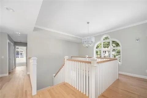 70 Shady Ln, Burrillville, RI 02859 - corridor with an upstairs landing, wood finished floors, a chandelier, baseboards, and crown molding