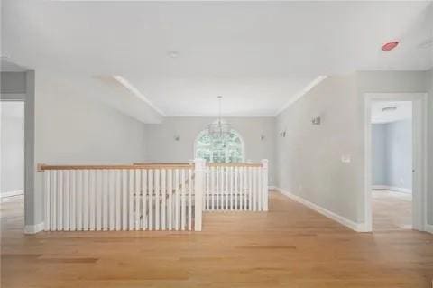 70 Shady Ln, Burrillville, RI 02859 - corridor featuring a chandelier, wood finished floors, and baseboards