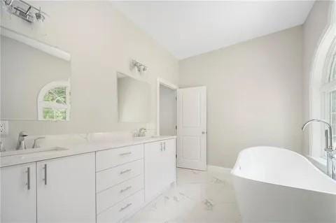 70 Shady Ln, Burrillville, RI 02859 - full bathroom featuring marble look tiles, double vanity, and a soaking tub