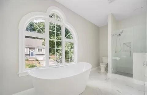 70 Shady Ln, Burrillville, RI 02859 - bathroom featuring a stall shower, a freestanding bath, toilet, marble finish flooring, and baseboards
