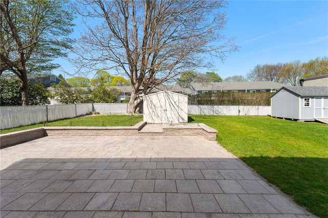 view of patio with a fenced backyard, a shed, and an outbuilding
