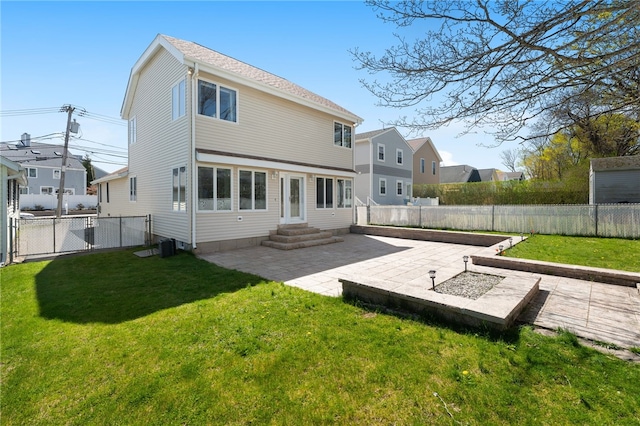 back of property with a fenced backyard, a patio area, a yard, and entry steps