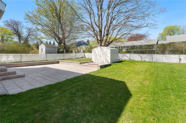 view of yard with a fenced backyard, a storage unit, an outdoor structure, and a patio area