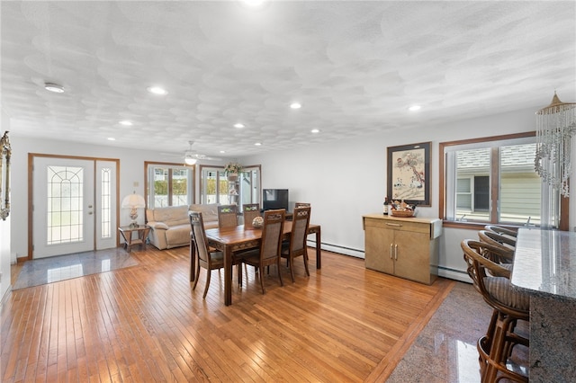 dining space with recessed lighting, ceiling fan, baseboard heating, and light wood-style floors