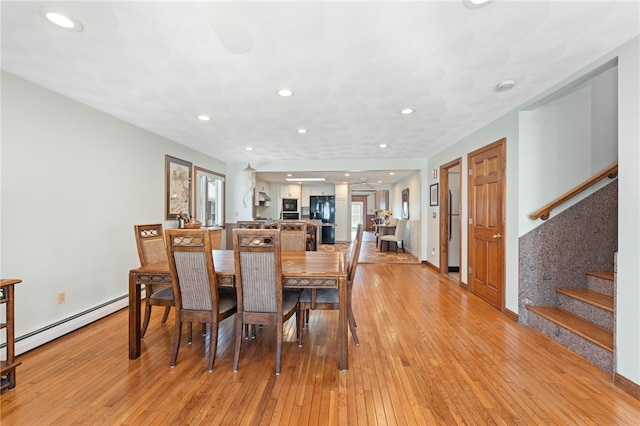 dining space with stairway, baseboard heating, recessed lighting, and light wood-style flooring