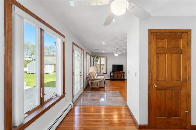 hallway with recessed lighting, baseboards, wood finished floors, and a baseboard radiator