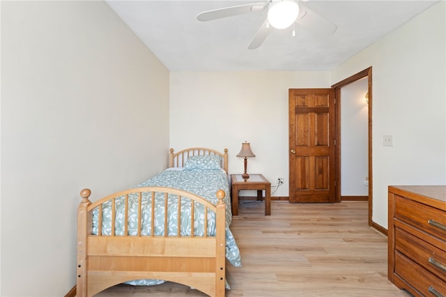 bedroom featuring light wood-style floors, baseboards, and a ceiling fan