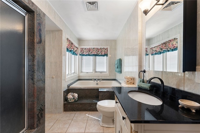 bathroom featuring visible vents, vanity, toilet, a bath, and tile patterned floors